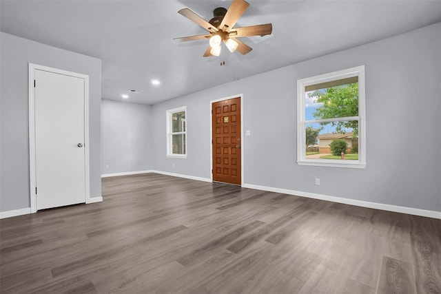unfurnished room with baseboards, visible vents, wood finished floors, and a ceiling fan