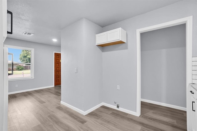 laundry area featuring light wood finished floors, laundry area, baseboards, visible vents, and recessed lighting