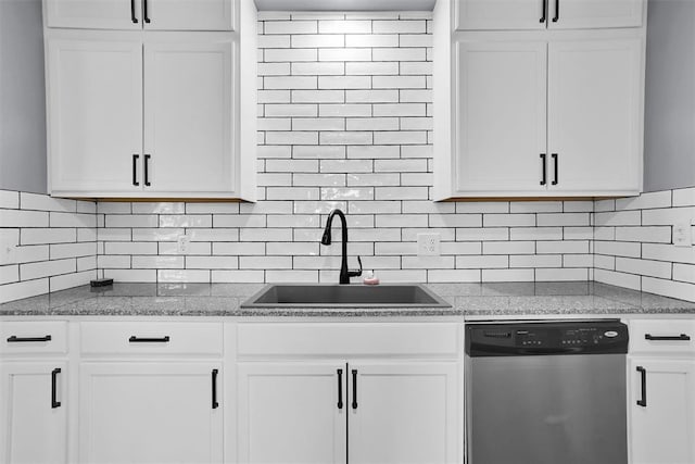 kitchen featuring stainless steel dishwasher, backsplash, white cabinets, and a sink