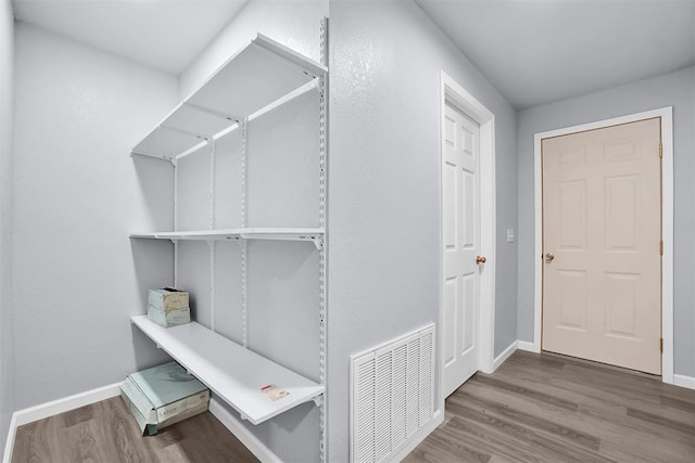 interior space with wood finished floors and visible vents