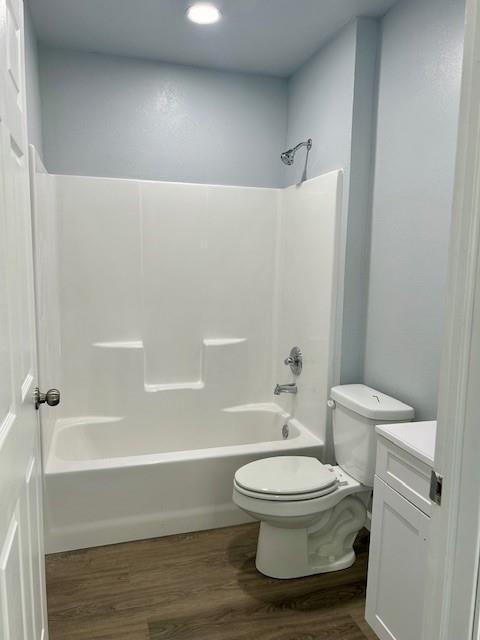 full bath featuring toilet, vanity, shower / bathtub combination, and wood finished floors