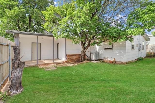 back of house featuring central air condition unit, a lawn, a patio area, and fence
