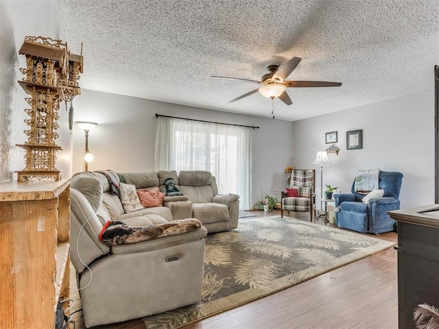 living room with ceiling fan, a textured ceiling, and hardwood / wood-style flooring