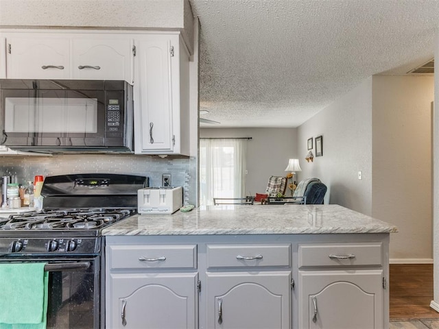 kitchen with decorative backsplash, a textured ceiling, black appliances, white cabinets, and hardwood / wood-style floors