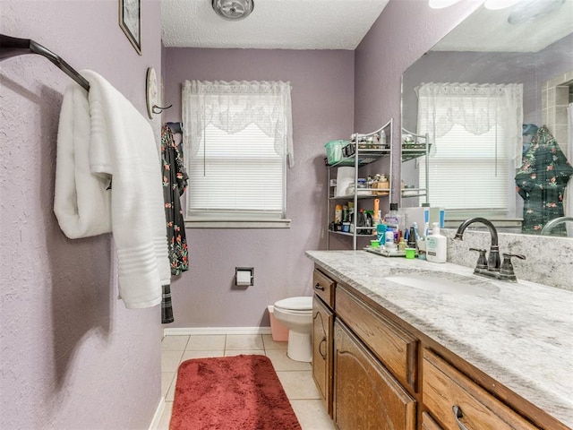 bathroom with tile patterned flooring, vanity, a textured ceiling, and toilet