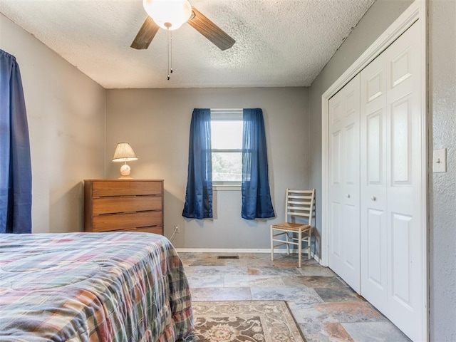 bedroom featuring a textured ceiling, a closet, and ceiling fan