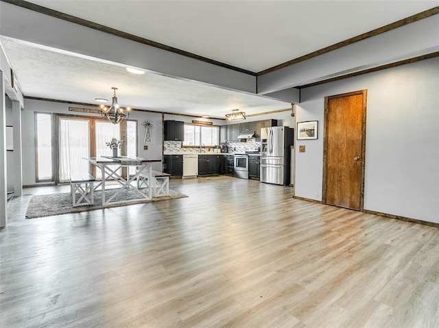 unfurnished living room featuring a chandelier, light hardwood / wood-style flooring, and crown molding