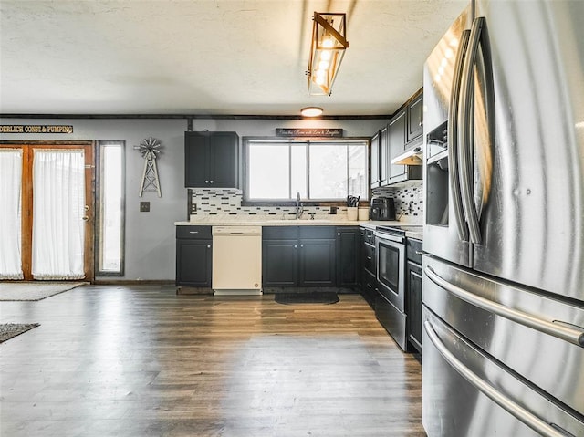 kitchen with backsplash, sink, hardwood / wood-style floors, and appliances with stainless steel finishes