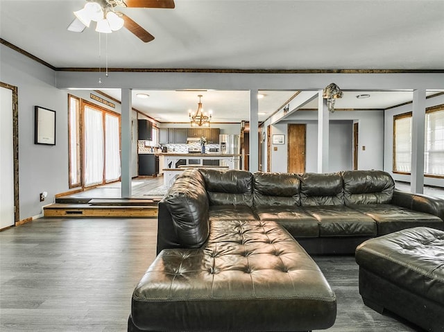 living room featuring ceiling fan with notable chandelier, hardwood / wood-style flooring, and crown molding