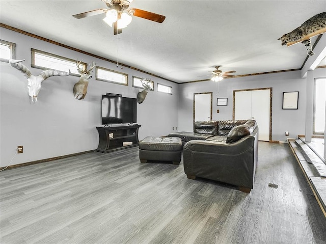 living room featuring ceiling fan, ornamental molding, and hardwood / wood-style flooring