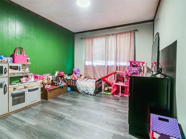 rec room with wood-type flooring, crown molding, and wooden walls