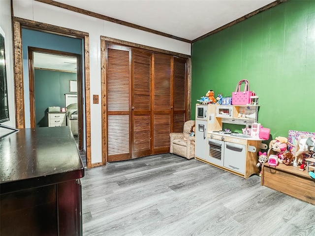 game room with crown molding and light hardwood / wood-style flooring