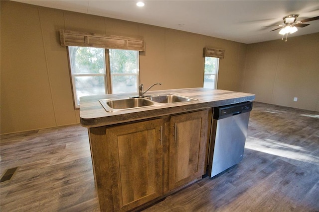 kitchen with a wealth of natural light, dishwasher, dark wood-type flooring, and sink