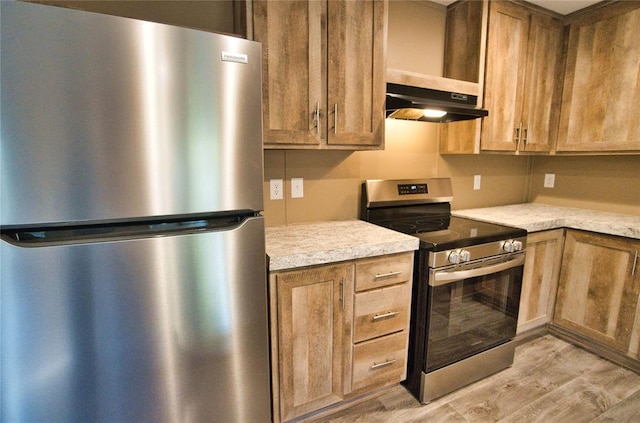 kitchen featuring stainless steel appliances, extractor fan, and light wood-type flooring