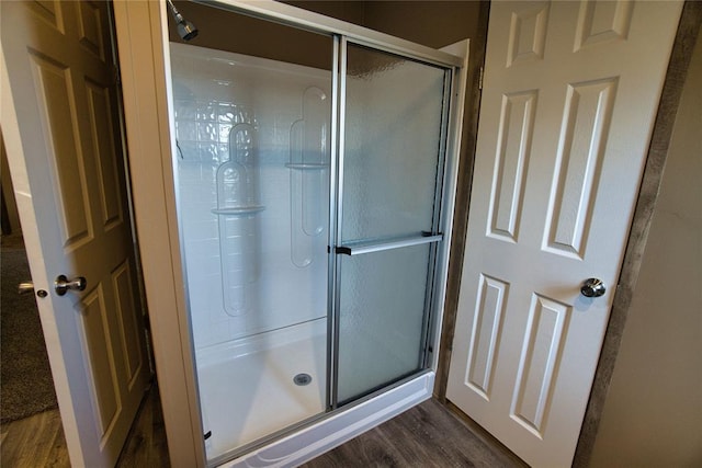 bathroom featuring wood-type flooring and an enclosed shower