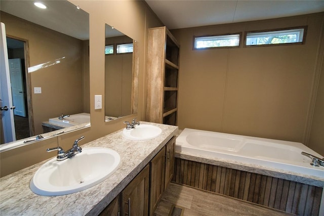 bathroom with vanity, hardwood / wood-style flooring, and a bathing tub