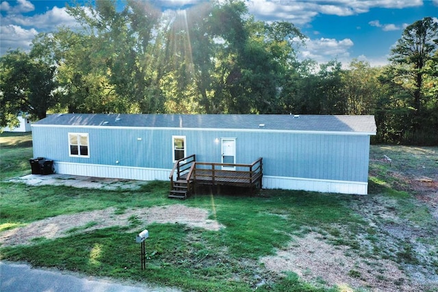 back of house featuring a lawn and a deck