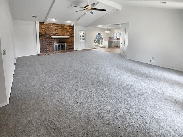 unfurnished living room with carpet, vaulted ceiling with beams, ceiling fan, and a fireplace