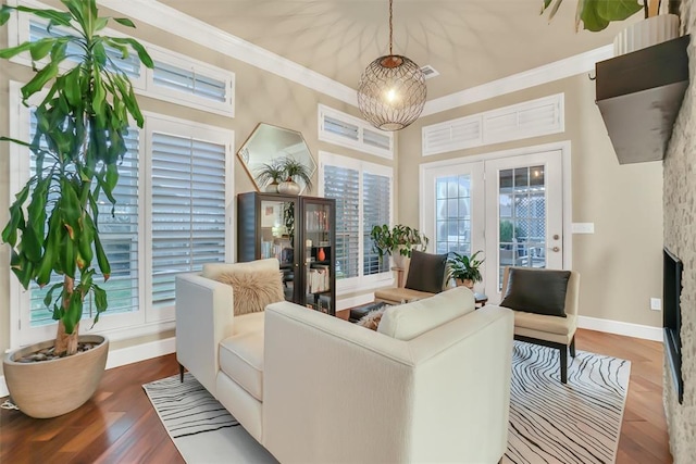 living room with light wood-type flooring, ornamental molding, and a wealth of natural light