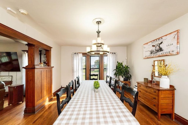 dining area featuring a chandelier, hardwood / wood-style flooring, and baseboard heating