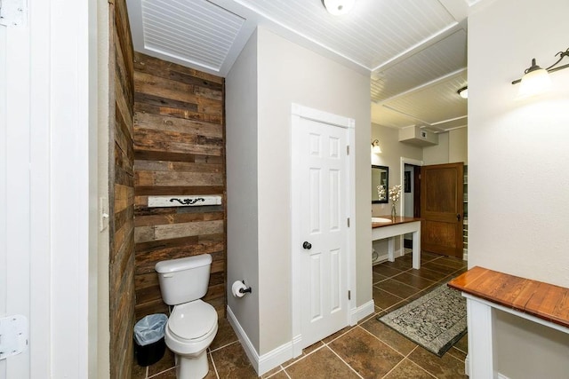 bathroom featuring wooden walls, tile patterned flooring, and toilet