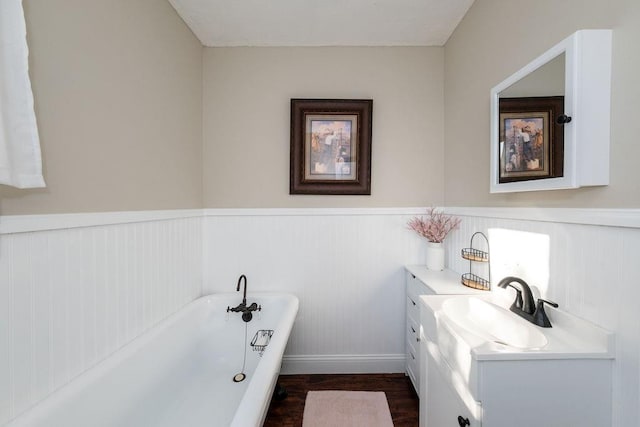 bathroom with a bathtub, vanity, and hardwood / wood-style flooring