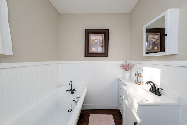 611 Wichita Ave, Devol, OK 73531 - bathroom featuring a freestanding bath, wainscoting, wood finished floors, vanity, and baseboards