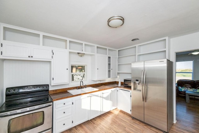 kitchen with sink, stainless steel appliances, a wealth of natural light, and light hardwood / wood-style flooring