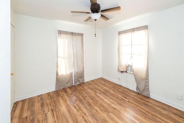 spare room featuring light wood-type flooring, a wealth of natural light, and ceiling fan