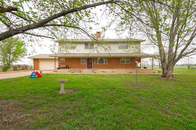 back of house with a lawn and a garage