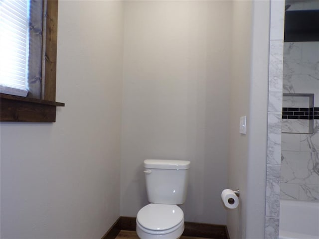 bathroom with tiled shower / bath combo and toilet