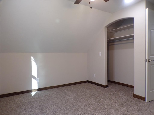 unfurnished bedroom with ceiling fan, vaulted ceiling, and a closet