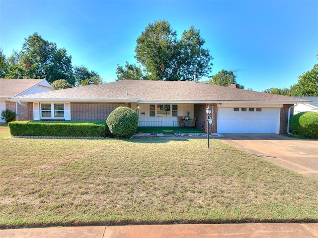 ranch-style house featuring covered porch, a garage, and a front lawn