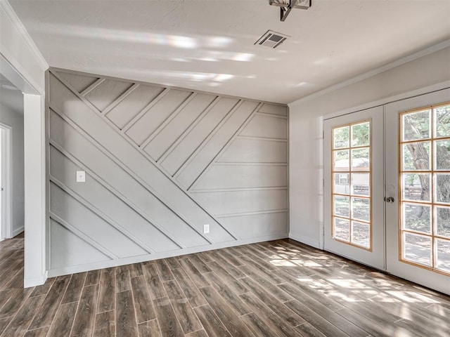 empty room featuring crown molding, dark wood-type flooring, and french doors