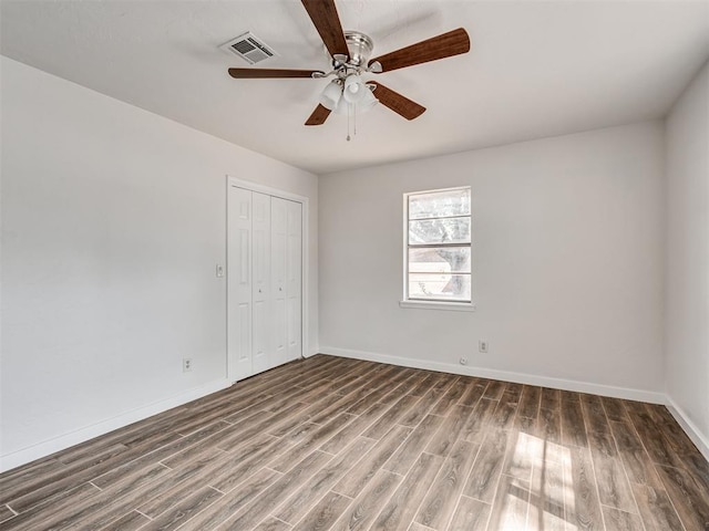 empty room featuring ceiling fan and dark wood-type flooring