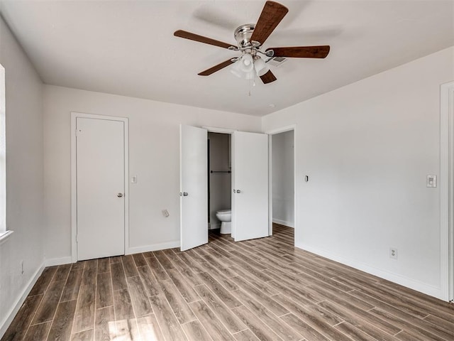 unfurnished bedroom with hardwood / wood-style flooring, ceiling fan, and connected bathroom