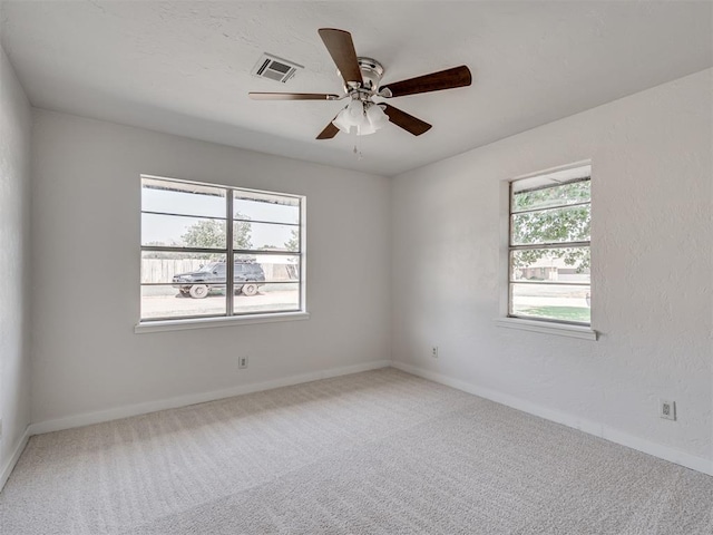 spare room with a wealth of natural light, carpet, and ceiling fan