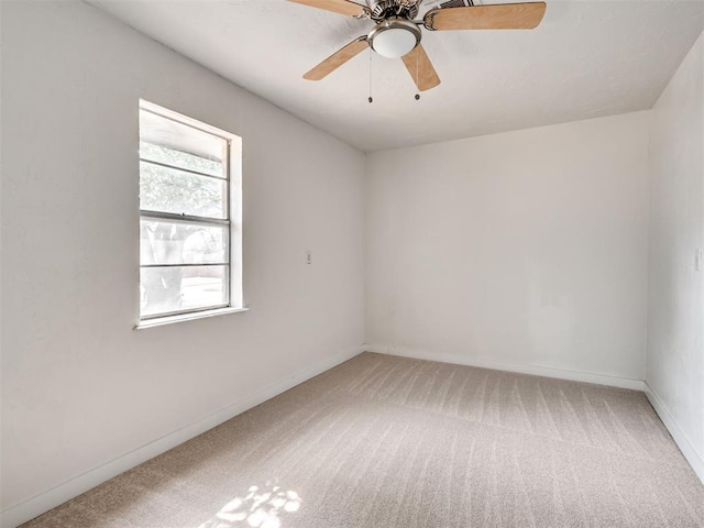 empty room featuring ceiling fan and carpet