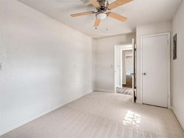 unfurnished room with ceiling fan and light carpet