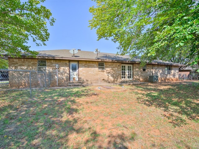 rear view of property featuring central air condition unit, a yard, and french doors