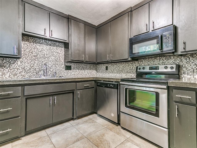 kitchen featuring sink, stainless steel appliances, tasteful backsplash, dark brown cabinets, and light tile patterned flooring