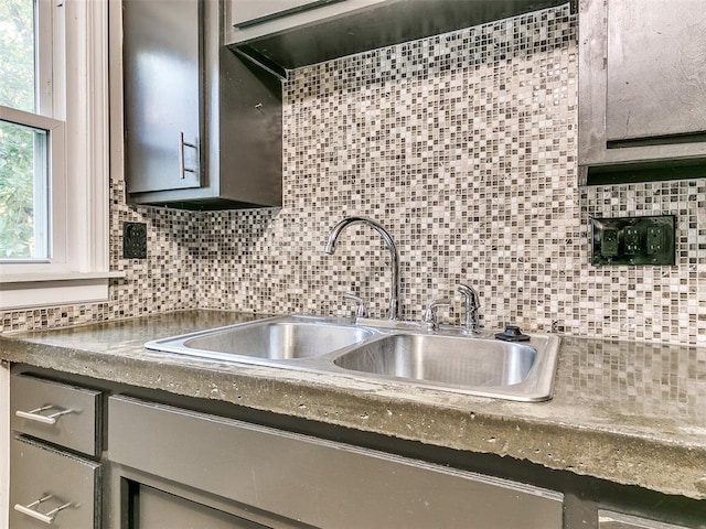 kitchen with decorative backsplash, gray cabinets, and sink