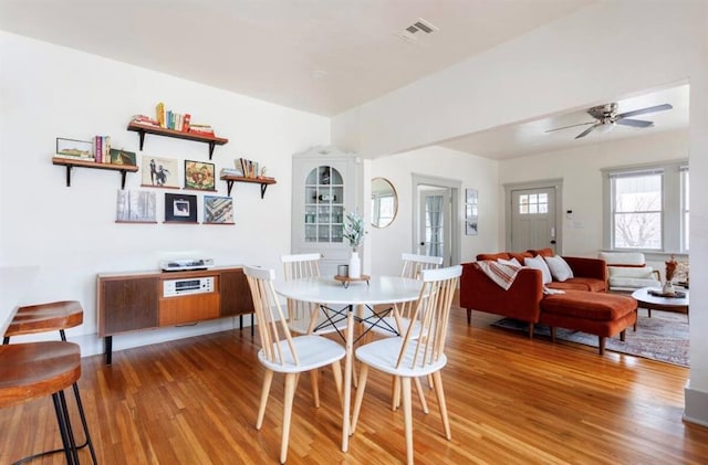 dining space with hardwood / wood-style flooring and ceiling fan