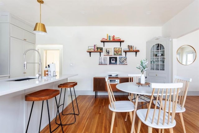 dining space featuring hardwood / wood-style floors and sink