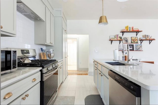 kitchen with pendant lighting, sink, wall chimney exhaust hood, tasteful backsplash, and stainless steel appliances