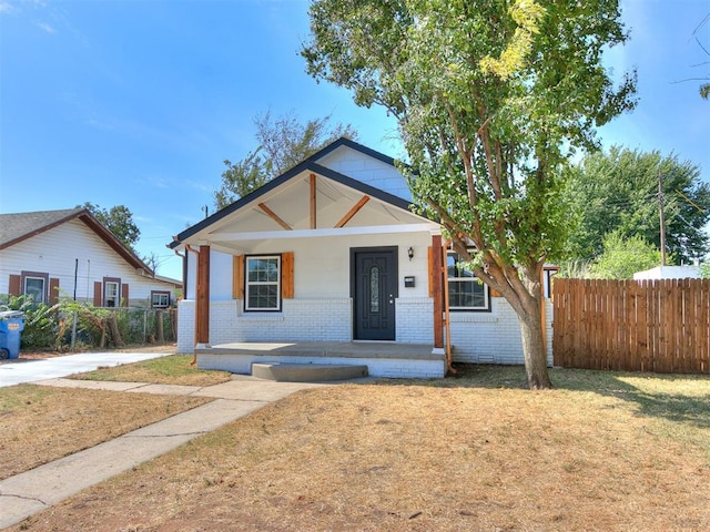 bungalow-style home featuring a porch and a front lawn