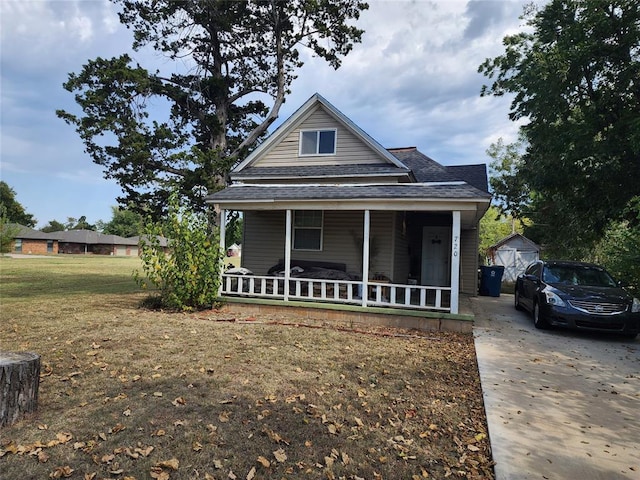 bungalow featuring covered porch and a front lawn