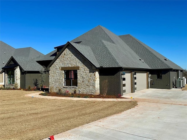 view of front facade with a front yard, a garage, and central AC unit