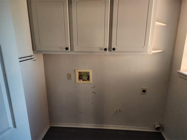 laundry area with electric dryer hookup, dark tile patterned floors, and washer hookup