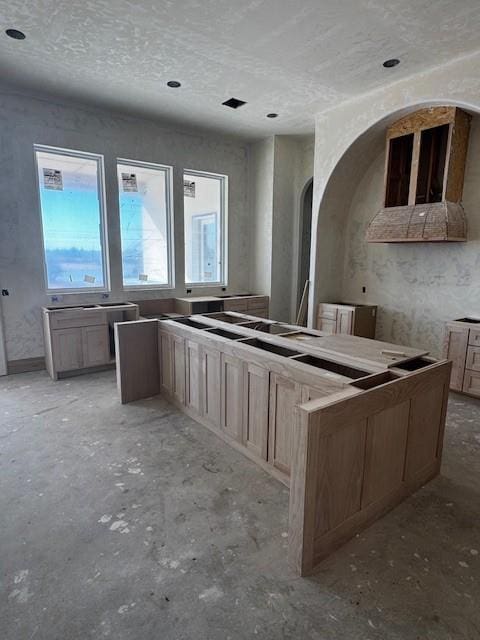 kitchen featuring a textured ceiling and light brown cabinets